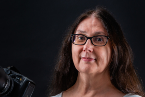 headshot of sue holding a camera